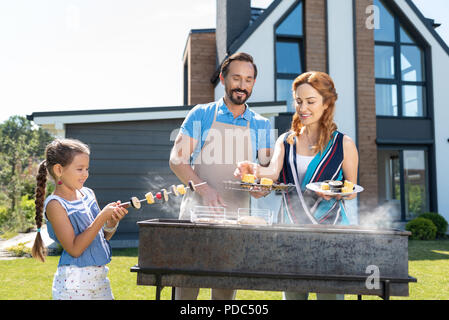 Bella donna positivo aiutando il marito Foto Stock