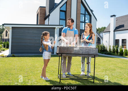 Positivi i genitori gioiosi guardando la loro figlia Foto Stock