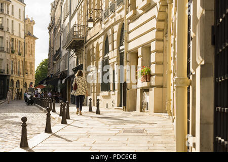 Paris Street scene - una donna a piedi lungo il luogo Dauphine sull'Ile de la Cite a Parigi nel tardo pomeriggio, in Francia, in Europa. Foto Stock