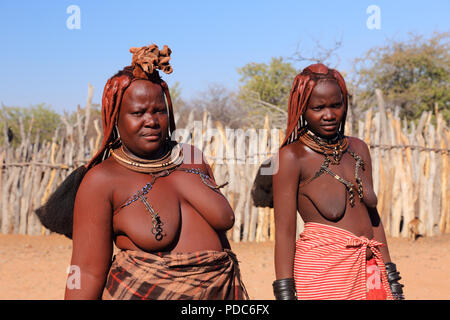Le donne himba, Namibia settentrionale. Ocra rossa pasta è utilizzata per purificare la pelle e aiutare le donne a proteggersi contro le punture di zanzara.. Foto Stock