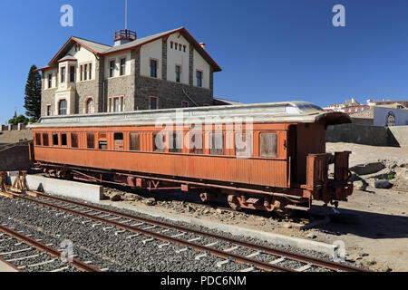 Un vecchio abbandonato e passeggero in disuso carrozza ferroviaria sorge nella stazione Luderitz, Namibia nella parte anteriore della storica casa Woermann. Foto Stock