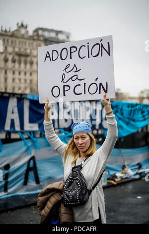 Buenos Aires, Argentina. 08 Ago, 2018. Una donna può contenere fino un poster a leggere 'L'adozione è l'opzione" durante una dimostrazione di fronte al palazzo del parlamento. Il 14 giugno 2018, l'Argentina la Camera dei Deputati ha approvato la legalizzazione dell aborto fino alla quattordicesima settimana di gravidanza. Il senato ha ad approvare la riforma oggi (08 agosto 2018). Credito: Pablo Albarenga/dpa/Alamy Live News Foto Stock