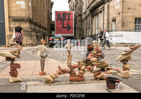 Edinburgh Fringe Festival di Edimburgo, Scozia, Regno Unito. 8 agosto 2018. Una pietra sovrapposti, Sterling Gregorio, costruisce pietra elaborate creazioni stack sul marciapiede durante la Edinburgh Fringe Festival. L'uomo è la costruzione di torri di pietra e gli archi nei pressi di un grande cartello che diceva arte e la raccolta di donazioni in un cappello come persone a piedi da Foto Stock