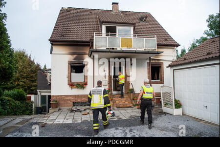 Wuppertal, Germania. 09Aug, 2018. 09.08.2018, della Renania settentrionale-Vestfalia, Wuppertal: due ufficiali delle forze di polizia e la fire chief approccio fulminazione di una casa. Due persone sono morte nella casa di fuoco. Credito: Christophe Gateau/dpa/Alamy Live News Foto Stock