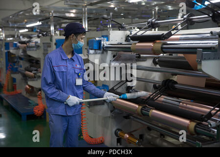 Tongling, cinese della provincia di Anhui. 8 Ago, 2018. Un membro del personale lavora su una linea di produzione della lamina di rame per la realizzazione di batterie al litio a Huachuang nuovo materiale Co., Ltd nella città di Tongling, est cinese della provincia di Anhui, e il Agosto 8, 2018. Tongling governo prende misure per migliorare il contesto ecologico e sviluppare industria verde lungo il fiume Yangtze. Credito: Jin Liwang/Xinhua/Alamy Live News Foto Stock