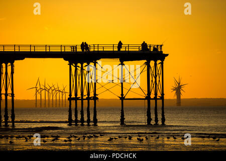 Tramonto dal molo vittoriano di Salburn con la fattoria eolica Teesside sullo sfondo. Saltburn sul mare, North Yorkshire, Inghilterra. REGNO UNITO. Foto Stock