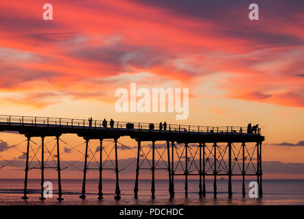 La gente a guardare il tramonto dal Salburn Victirian del molo. Saltburn dal mare, North Yorkshire, Inghilterra. Regno Unito. Agosto 2018. Foto Stock