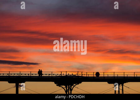 La gente a guardare il tramonto dal Salburn Victirian del molo. Saltburn dal mare, North Yorkshire, Inghilterra. Regno Unito. Agosto 2018. Foto Stock