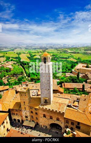 Unico San Gimignano village,vista con case tradizionali e torre,Toscana,l'Italia. Foto Stock