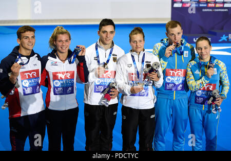 Gran Bretagna Ross Haslam e grazia Reid (argento) Germania Lou Massenberg e Tina Punzel (oro) e dell'Ucraina Stanislav Oliferchyk (bronzo) sul podio di miscelati Sychronised 3m Springboard durante il giorno sette del 2018 Campionati Europei a Scotstoun Sport Campus, Glasgow. Foto Stock