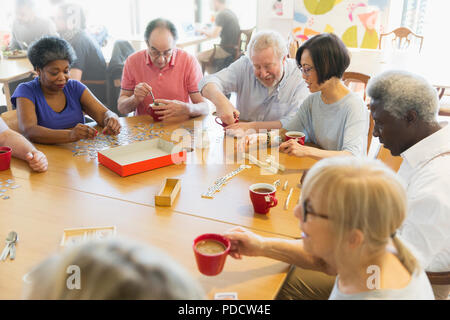 Senior amici a giocare giochi da tavola nella Comunità centro Foto Stock