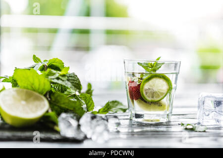 Vista ravvicinata di vetro con fragole fresche e kiwi mojito Foto Stock
