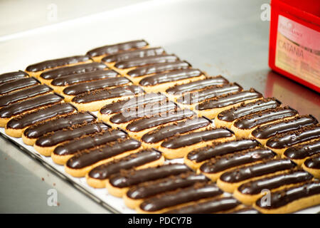 La colorata eclairs essendo realizzato presso l'Eclair de Genie laboratorio di cucina a Parigi, Francia Foto Stock