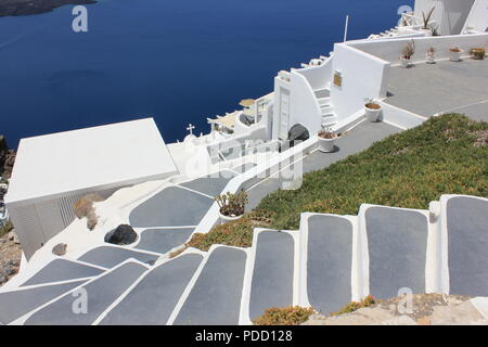 Vi avventurerete nella città sull isola di Santorini Grecia con edifici bianchi e accenti di blu, insieme con la caldera in background. Foto Stock