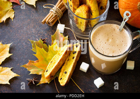 In autunno la cottura dello sfondo. Pane appena sfornato uvetta e cannella biscotti e una tazza di caffè cappuccino su un marrone ardesia ardesia o sfondo. Copia dello spazio. Foto Stock