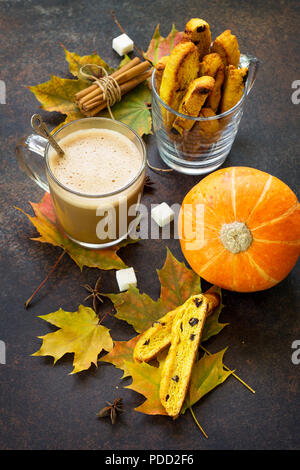 In autunno la cottura dello sfondo. Pane appena sfornato uvetta e cannella biscotti e una tazza di caffè cappuccino su un marrone ardesia ardesia o sfondo. Foto Stock