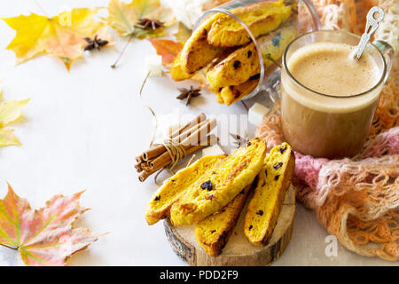 In autunno la cottura dello sfondo. Pane appena sfornato uvetta e cannella biscotti e una tazza di caffè cappuccino sulla lavagna luminosa o ardesia sfondo. Copia dello spazio. Foto Stock