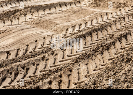 Grandi pneumatici per camion tracce sulla sabbia aperta superficie pit. Cava di macchinari pesanti concept Foto Stock