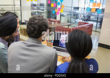 La gente di affari le videoconferenze al computer portatile in ufficio Foto Stock