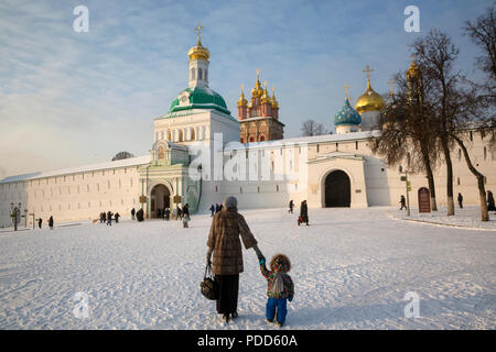 Una madre porta un bambino per il grande monastero della Trinità in Sergiyev Posad antica città russa, regione di Mosca, Russia Foto Stock