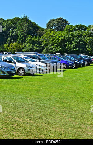 Temporanea del parco auto per far fronte ai vacanzieri realizzati utilizzando le aree di erba del locale campo di cricket a Saundersfoot, Pembrokeshire nel Galles Occidentale Foto Stock