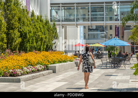 La donna a piedi attraverso il patio all'aperto presso il centro mercantile in Worcester, MA Foto Stock