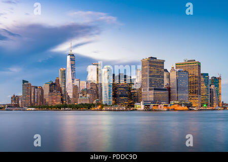 New York, New York, USA la parte inferiore di Manhattan Financial District skyline della città da tutto il porto di New York al crepuscolo. Foto Stock
