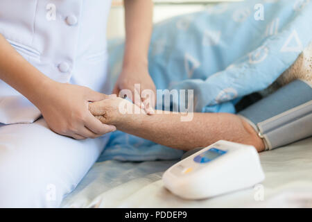 Donna medico misurata nel sangue del paziente anziano nella stanza di ospedale. . Settore medicale e della salute in persone anziane concept Foto Stock