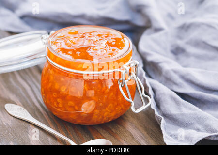 Vaso di vetro con cloudberry inceppamento. Cucina nordica. Foto Stock