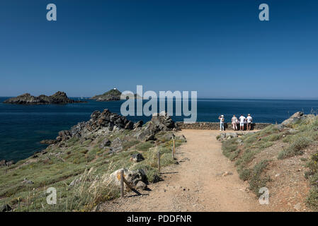 I visitatori alla fine del sentiero lastricato sul Pointe de la Parata, ( punto della Parata ) sulla Corsica verso una catena di piccole isole, Les Archipel des Sangui Foto Stock