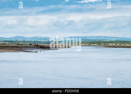 La vecchia gru funziona e turbine eoliche sull'Ayrshire colline in lontananza da Irvine Harbour nel North Ayrshire in Scozia. Foto Stock