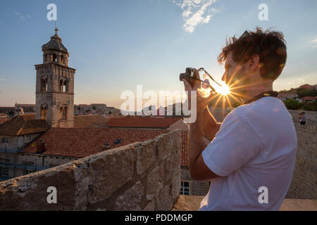 Turistica prendendo le foto della città vecchia di Dubrovnik con una fotocamera compatta Foto Stock