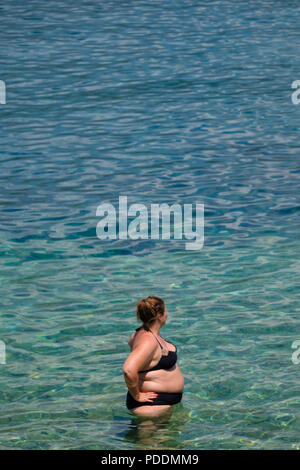 Donna sovrappeso in spiaggia Foto Stock