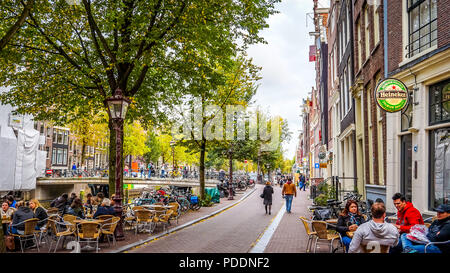 Una bella giornata di caduta per un pranzo su una delle tante terrazze lungo il canal grande e con molte moto parcheggiata nel centro di Amsterdam, Paesi Bassi Foto Stock