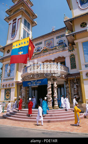 I monaci in vesti colorati sui passi al Gran Tempio Cao Dai, Long Hoa, a Tay Ninh vicino a Ho Chi Minh City in Vietnam per solo uso editoriale Foto Stock