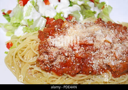 Cuocere gli spaghetti e rabboccato con una deliziosa casa al sugo di carne e formaggio parmigiano grattugiato fresco e un fresco giardino insalata di contorno e rabboccato con crema Foto Stock