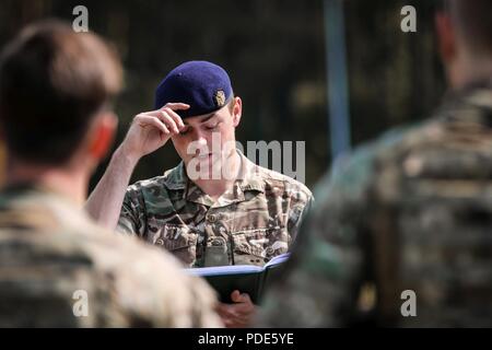 Esercito DEL REGNO UNITO 1Lt. Hugo Chaplin, truppa leader con 1 Queen's Dragoon Guards, dà una breve di sicurezza per i suoi soldati prima di iniziare il primo dei quattro giorni di addestramento alle armi evento con il gruppo di combattimento della Polonia a Bemowo Piskie Area Formazione, Polonia, il 15 maggio 2018. Gruppo di combattimento della Polonia è un luogo unico e multinazionale di coalizione di Stati Uniti, Regno Unito, croato e soldati rumeni che servono con il polacco della XV Brigata meccanizzata come una forza di dissuasione a sostegno della NATO in avanti rafforzata presenza. Foto Stock