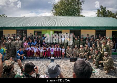 Forze multinazionali, facoltà e personale, illustri visitatori, e gli studenti si riuniscono di fronte ad una di nuova costruzione edificio scolastico dopo una cerimonia a sostegno dell'esercizio Balikatan Cabu alla scuola elementare di Cabanatuan City, Nueva Ecija, Filippine, 16 maggio 2018. Esercizio Balikatan, nella sua trentaquattresima iterazione è un annuale U.S.-militari filippini esercizio di formazione incentrati su una varietà di missioni, comprese la fornitura di assistenza umanitaria e di soccorso in caso di catastrofe, la lotta contro il terrorismo e altri combinato operazioni militari svoltasi dal 7 Maggio al 18. Foto Stock