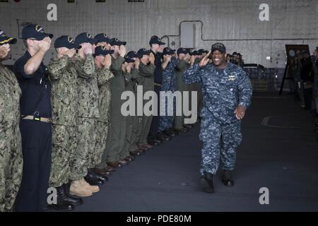 NORFOLK, Virginia (17 maggio 2018) - Chief Warrant Officer Derrick Lee restituisce il saluto di USS Gerald Ford (CVN 78) marinai come egli si diparte la nave per il suo comando successivo. Foto Stock