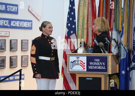 Rappresentante Claudia Tenney, New York congressista, si prepara a mano Master Sgt. Meghann Viggiani una rosa in onore del suo coraggio e realizzazioni professionali come il Marine Corps' senior sottufficiale riconosciuto alla donna nella corona militare la cerimonia di posa, sponsorizzato dal Congressional Caucus per le questioni femminili, Arlington, Virginia, 17 maggio 2018. Viggiani, la logistica capo nella caserma di Marina di Washington è stato riconosciuto in occasione della cerimonia annuale. Foto Stock