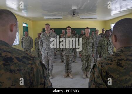 Stati Uniti Avieri, Marines e marinai stand in formazione per una cerimonia di premiazione come parte della cerimonia a Luga Scuola Elementare, Santa Teresita, Cagayan, Filippine, 18 maggio 2018, durante l'esercizio Balikatan. Esercizio Balikatan, nella sua trentaquattresima iterazione è un annuale U.S.-militari filippini esercizio di formazione incentrati su una varietà di missioni, comprese la fornitura di assistenza umanitaria e di soccorso in caso di catastrofe, la lotta contro il terrorismo e altri combinato operazioni militari svoltasi dal 7 Maggio al 18 maggio. Foto Stock