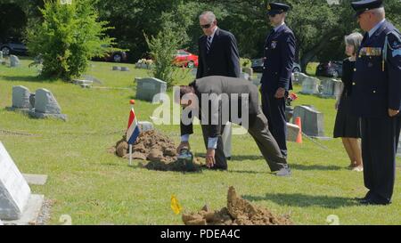 Lt. Col. (Ret). Pieter Cramerus, figlio di Capt. Pieter A. Cramerus, luoghi di suo padre a rimane nel loro ultimo luogo di riposo durante una commemorazione e cerimonia commemorativa in onore del senior Cramerus e l'olandese volantini presso il prato di cedro cimitero di Jackson, Miss., 19 maggio 2018. Cramerus, un pilota con le Indie orientali olandesi si riserva militare, era uno dei numerosi volantini olandese che ha addestrato con il Royal Netherlands militare Scuola di Volo a Hawkins campo aereo di Jackson durante la Seconda Guerra Mondiale. Foto Stock