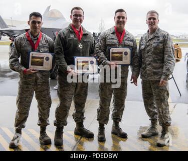 Stati Uniti Air Force Col. Mathew Powell, comandante del terzo gruppo di manutenzione, sorge con Staff Sgt. Randall Stoiner, Airman 1. Classe Giuseppe pagina e Senior Airman Justin Rios come essi sono riconosciuti come vincitori dell'ala armi Equipaggio di carico 1° trimestre la concorrenza Maggio 18, 2018 a base comune Elmendorf-Richardson, Alaska. Un carico di armi equipaggio è un gruppo di tre persone responsabili per la preparazione e il caricamento di munizioni su un aeromobile. Foto Stock