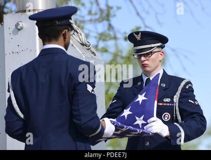 Avieri dal Ellsworth Air Force Base di guardia d'onore la piegatura di un flag durante una cerimonia di ritiro a Ellsworth AFB, S.D., 15 maggio 2018. Il 28 forze di sicurezza Squadron ha ospitato un ritiro cerimonia durante la polizia nazionale alla settimana per ricordare caduti difensori e onorare la applicazione della legge comunitaria. Foto Stock