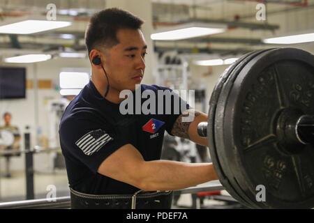 Stati Uniti Army Sgt. Curtis Sua, un fante assegnato a seconda della brigata di fanteria combattere la squadra, 4a divisione di fanteria, fissa i pesi su un barbell, 17 maggio 2018, a un fisico centro fitness a Kandahar Airfield, Afghanistan. Sua, nativo di Las Vegas, Nevada, ha recentemente guadagnato un posto come un membro del 1000-pound club presso la NATO fisica centro fitness. Foto Stock