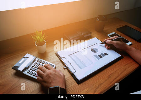 Imprenditori calcolare il reddito da attività di esportazione sul tavolo in legno.La concezione di business. Foto Stock