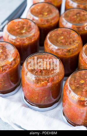 In casa conserve di pomodoro la salsa in un barattolo di vetro. Alimenti biologici. Foto Stock