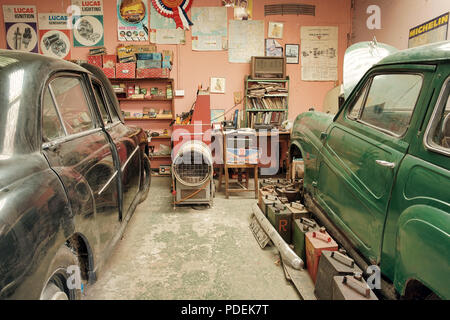 Due automobili classiche in un vecchio stile in garage per la manutenzione e la riparazione Foto Stock