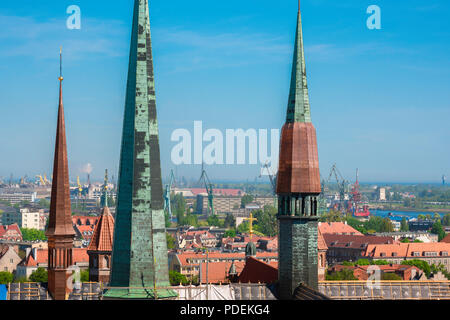 Lo skyline di Danzica, vista sulle guglie della chiesa di Santa Maria con le gru del cantiere di Danzica visibile in distanza, Pomerania, Polonia. Foto Stock