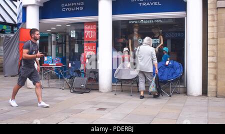 Un uomo cammina attraverso Buxton area dello shopping portando una grande back pack Foto Stock